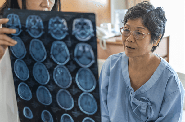 elderly woman with brain injury looking at CT scan