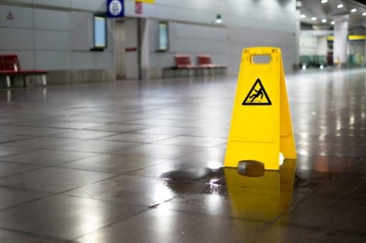 Puddle On The Floor With A Wet Floor Sign