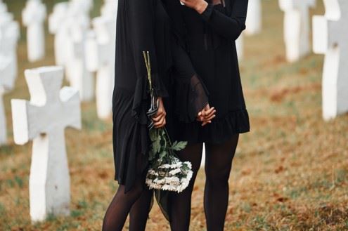 two young women holding flowers at a funeral