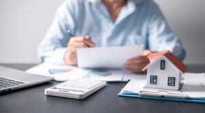 House with money. Concept of finance or refinance real estate. Symbol of house stands against background of us dollars. Property investment. Home mortgage loan rate. Saving money for retirement.