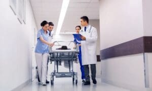 A Guide to Medical Bills & Compensation in North Carolina Personal Injury Claims - Payne Law Firm medics with woman on hospital gurney at emergency