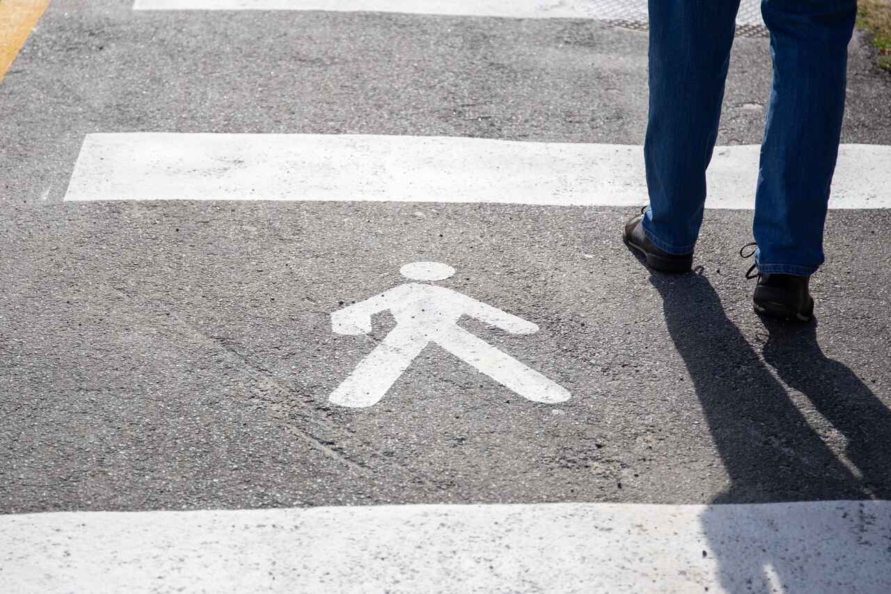 pedestrian sign on asphalt with a person walking across