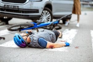 Road accident with injured cyclist and car
