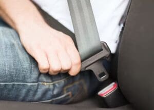 Charlotte Hit and Run Accident Lawyer - Payne Law Firm A person wearing jeans is fastening a seatbelt in a car.