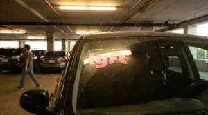 Charlotte Hit and Run Accident Lawyer - Payne Law Firm Lyft logo sticker displayed on vehicle windshield inside parking garage