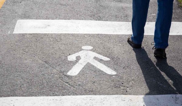 pedestrian sign on asphalt with a person walking across